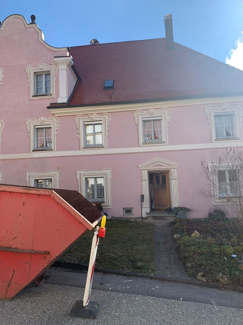 Altbau-Baustelle mit Container vor dem Haus